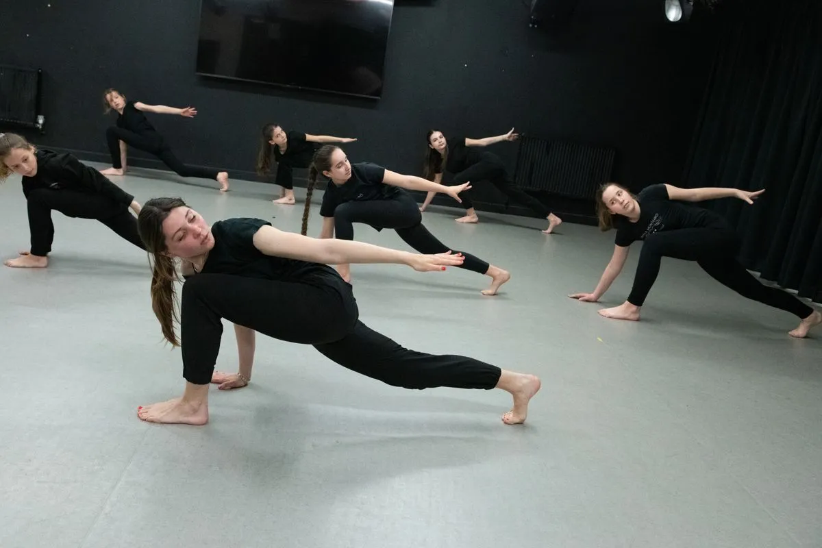 Senior contemporary dancers moving together across the studio floor